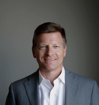 Brad Kendall in a suit smiling