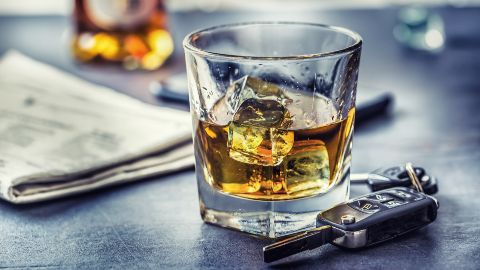 Whiskey glass with car keys nearby