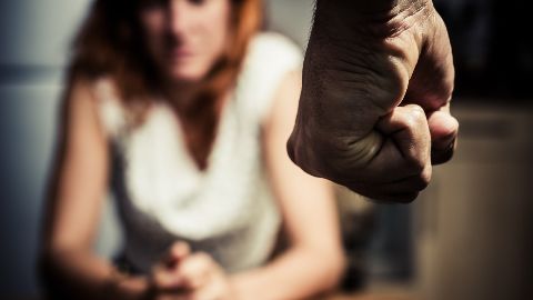 Woman in fear of a man with a clenched fist