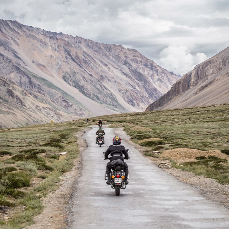 People riding on motorcycles through a valley