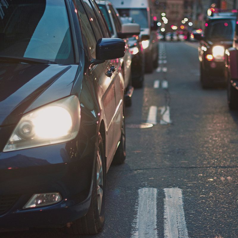 Cars with their headlights on in traffic