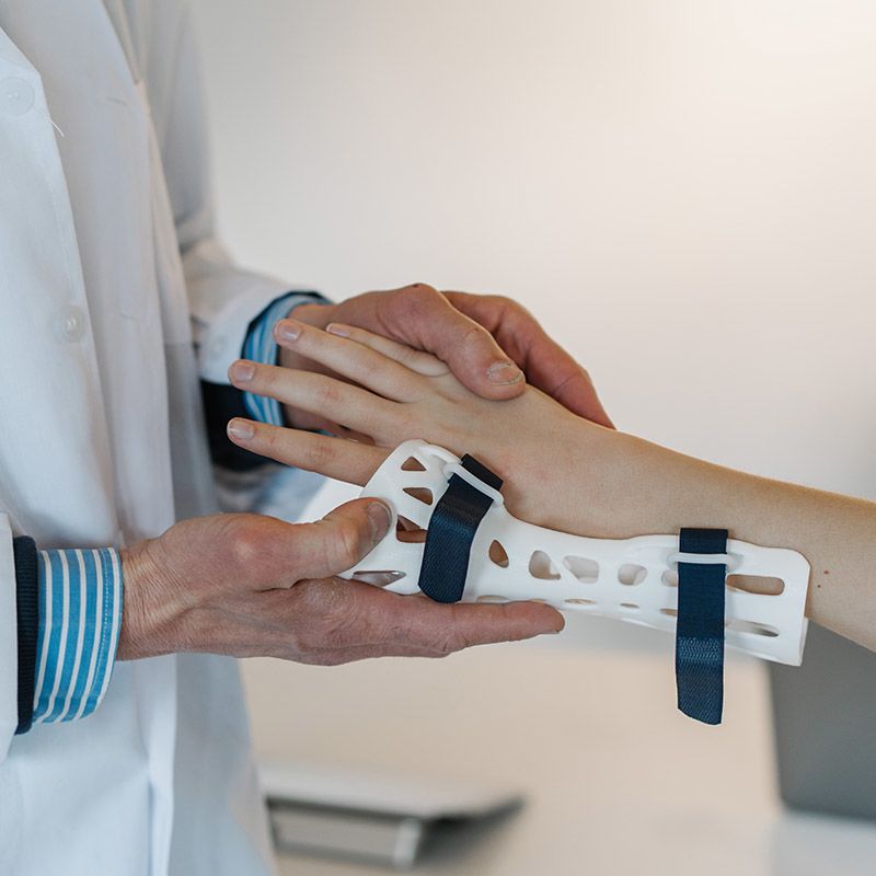 Doctor putting a splint on a girl's arm