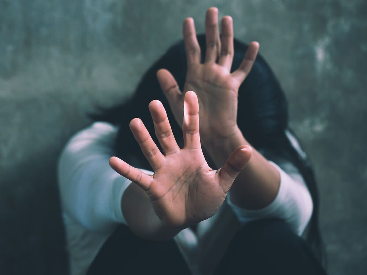 Distressed woman holding out her arms motioning to stop