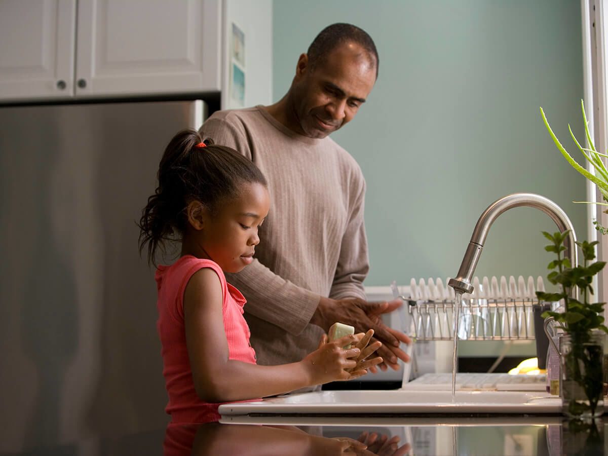 Man and girl washing dishes together