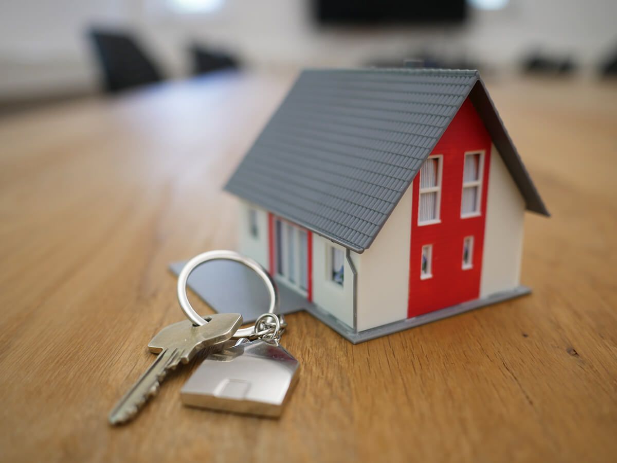 Tiny 3D model of house next to set of keys