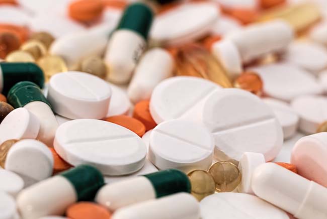 Pills sitting on a table in different shapes and sizes