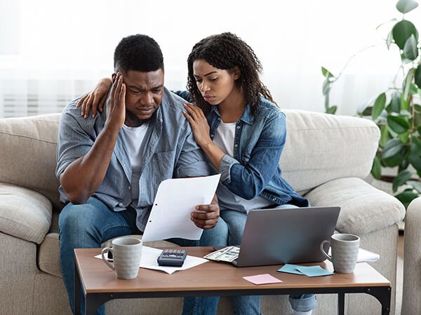 Distressed couple looking at computer and documents