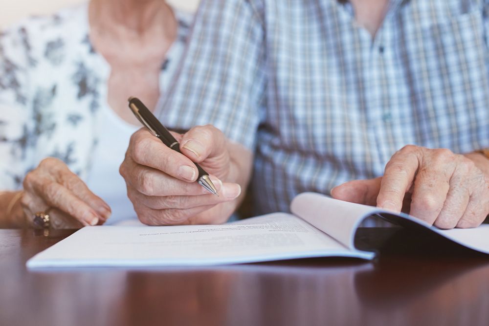 Older couple signing a will together
