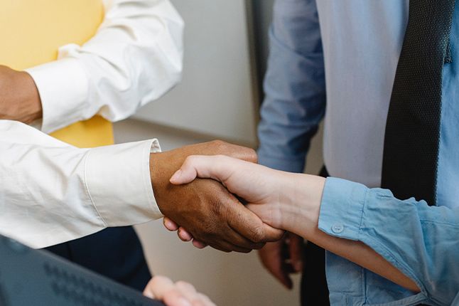 People shaking hands while working