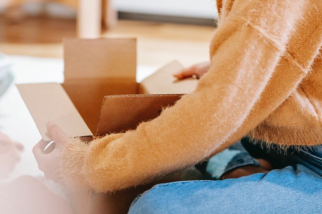 Woman packing with a cardboard box