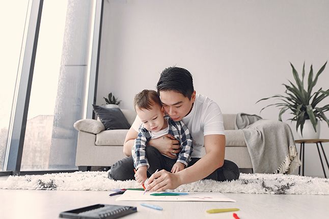 Man coloring on the floor with a kid