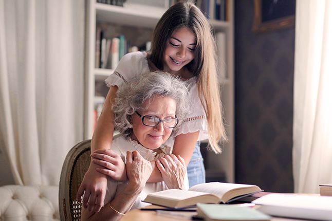 Young girl reading with her grandmother