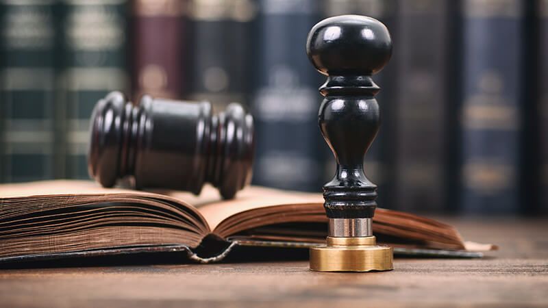 Gavel, open law book, and notary stamp