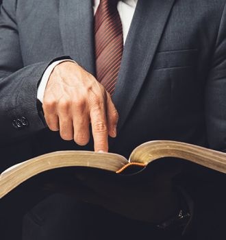 Man in suit pointing to a page in an open book